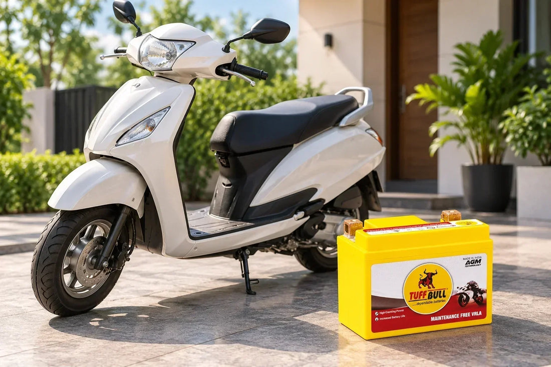 Tuff Bull two-wheeler battery displayed beside a white scooter outside a residential home